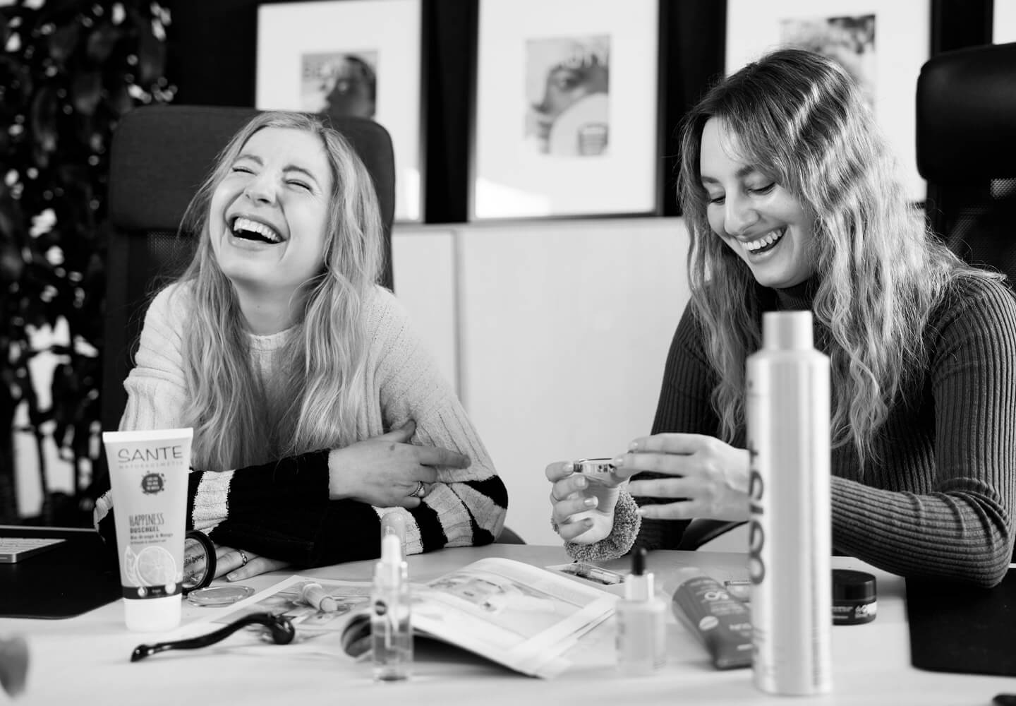 Zwei Personen sitzen an einem Tisch und lachen