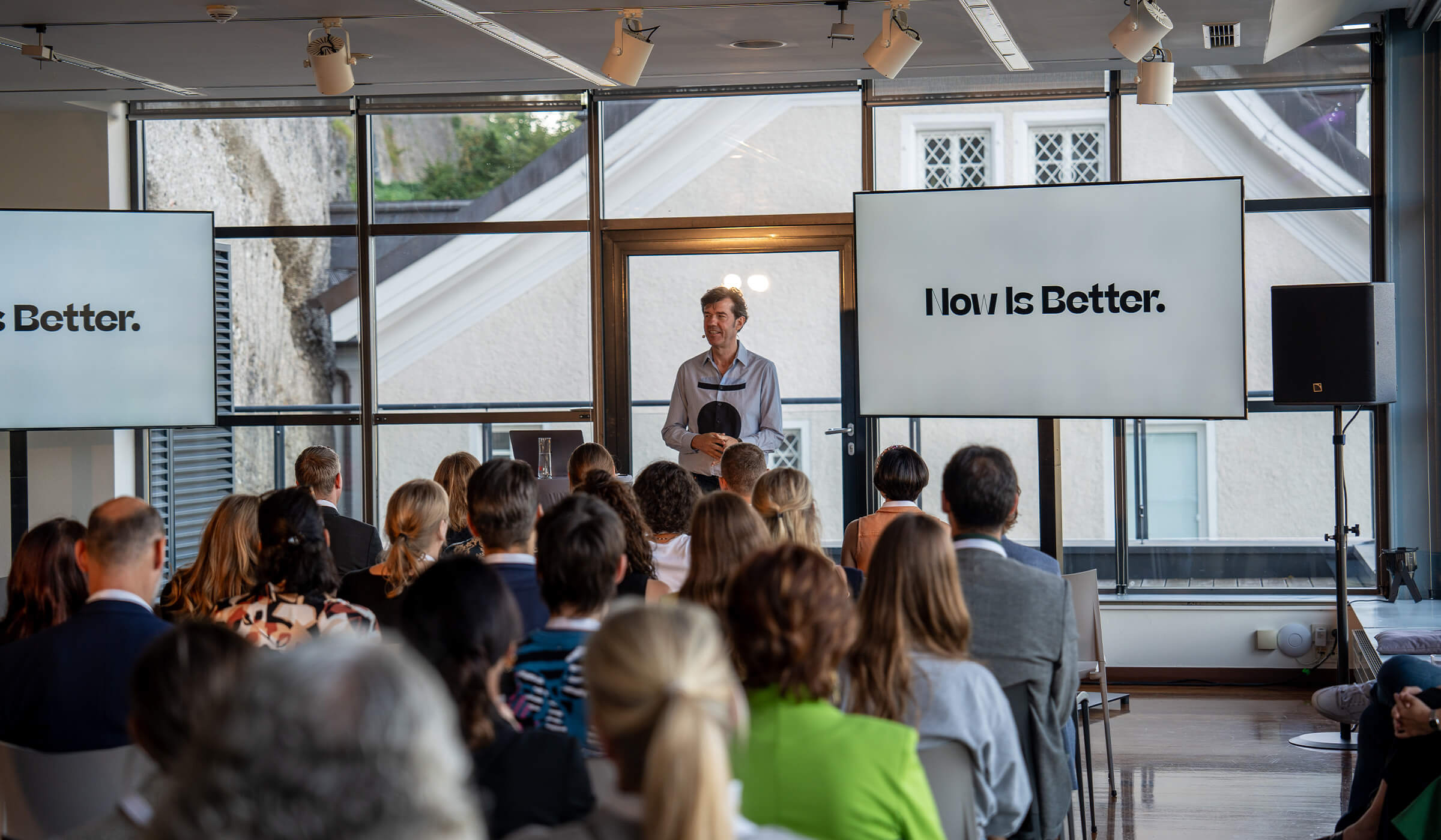 Stefan Sagmeister spricht vor einem Publikum im Penthouse des LOFT Salzburg.