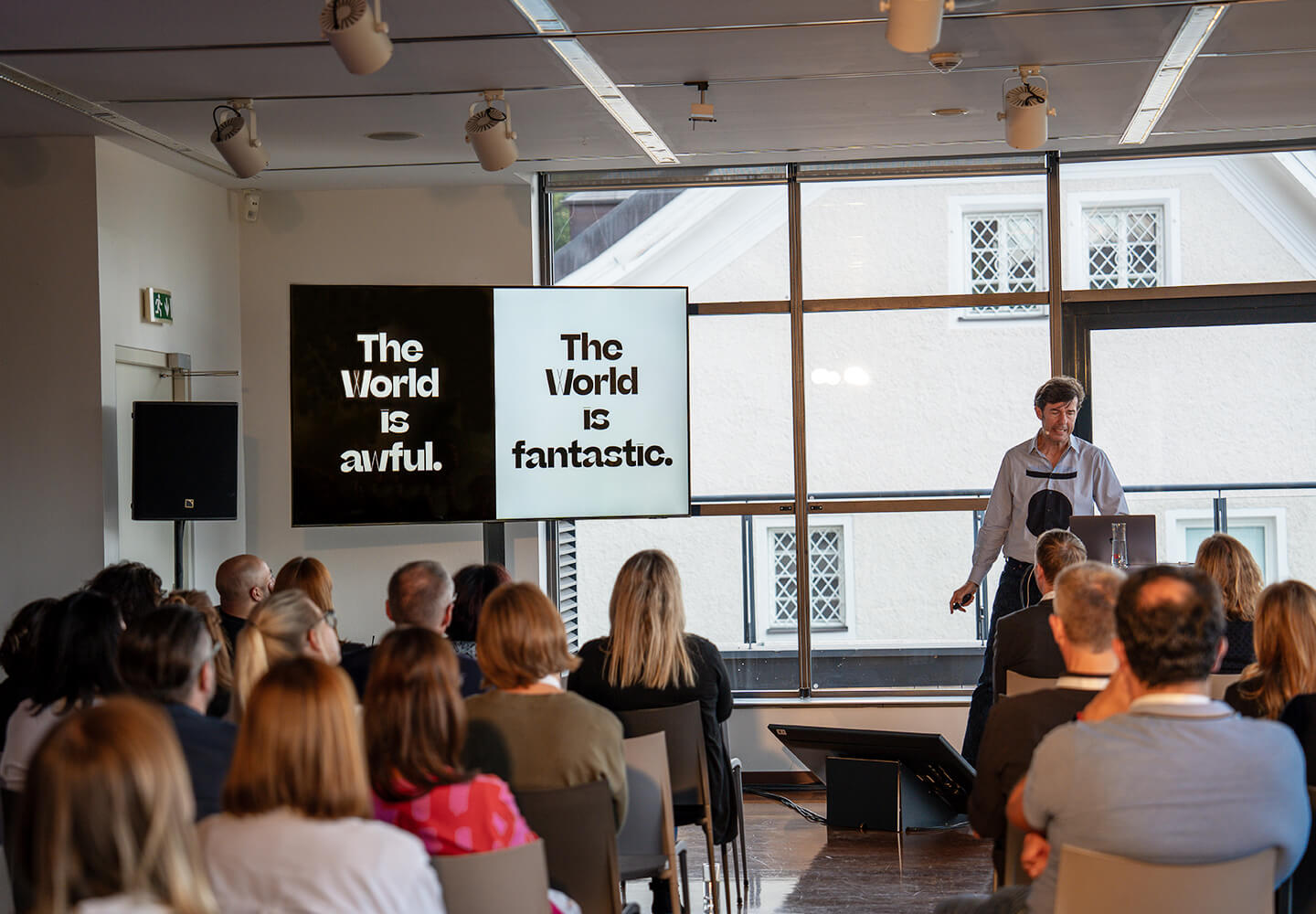 Stefan Sagmeister spricht vor einem Publikum im Penthouse des LOFT Salzburg.