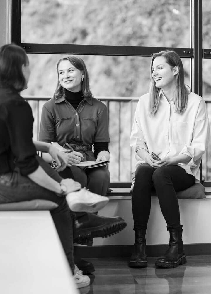 Mehrere Personen sitzen nebeneinander und lachen.