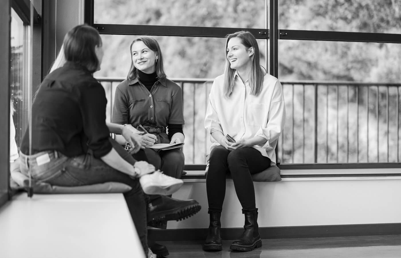 Mehrere Personen sitzen nebeneinander und lachen.