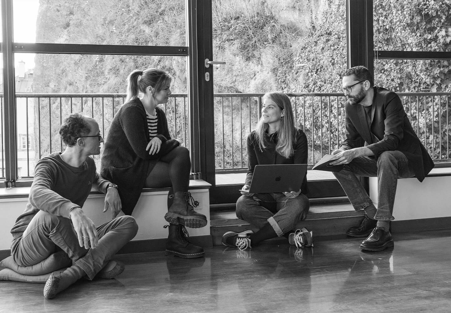 Vier Personen sitzen im Penthouse des LOFT Salzburg.